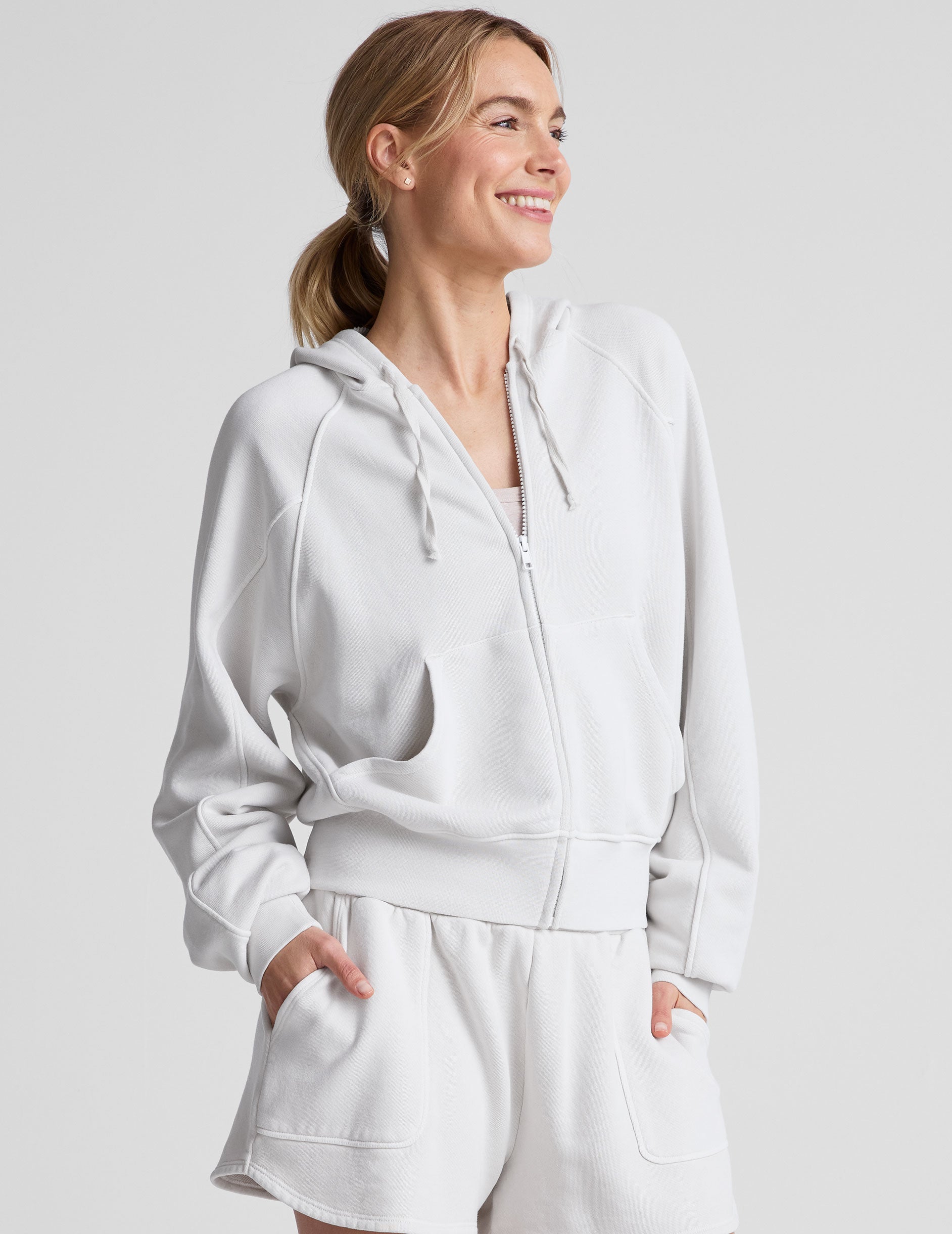 white zip-up jacket with hoodie and pockets.